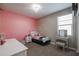 Bedroom with twin bed, vanity, and pink accent wall at 29362 W Weldon Ave, Buckeye, AZ 85396