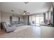 Living room with gray sectional sofa, backyard access, and ceiling fan at 29362 W Weldon Ave, Buckeye, AZ 85396