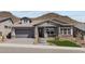 Charming single-story home featuring a stone-accented facade, gray exterior, and well-manicured landscaping at 32496 N 135Th Dr, Peoria, AZ 85383
