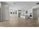 Open-concept kitchen and living space featuring white cabinets, stainless steel appliances, and pendant lighting at 32496 N 135Th Dr, Peoria, AZ 85383