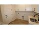 Practical laundry room with cabinets, a utility sink, and a tiled floor, for convenient chores at 32496 N 135Th Dr, Peoria, AZ 85383