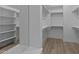Bright walk-in closet featuring custom shelving, wooden racks, and modern wood-look floors at 32496 N 135Th Dr, Peoria, AZ 85383