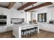 Modern kitchen with white cabinets, marble island, and exposed beams at 3370 N 55Th Pl, Phoenix, AZ 85018