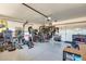 Garage with home gym setup, featuring a weight bench and other exercise equipment at 3610 N 106Th Ave, Avondale, AZ 85392