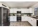 Modern kitchen with white cabinets, stainless steel appliances, and gray tile floors at 3610 N 106Th Ave, Avondale, AZ 85392