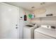 Bright laundry room with washer, dryer, and extra storage shelving at 3610 N 106Th Ave, Avondale, AZ 85392