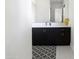 Stylish bathroom with dark vanity and geometric rug at 3928 E Crittenden Ln, Phoenix, AZ 85018