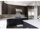 Modern kitchen with dark cabinetry, stainless steel appliances, and hexagon tile backsplash at 3928 E Crittenden Ln, Phoenix, AZ 85018