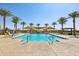 Community swimming pool with palm trees and lounge chairs at 4145 E Kolin Ln, San Tan Valley, AZ 85143