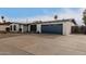 Exterior view of a single-story home with a gray garage door and desert landscaping at 4639 W Becker Ln, Glendale, AZ 85304