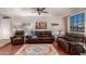 Living room featuring brown leather furniture, wood floors, and a large TV at 4639 W Becker Ln, Glendale, AZ 85304