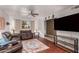 Spacious living room with brown leather furniture, wood floors, and large window at 4639 W Becker Ln, Glendale, AZ 85304