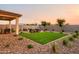 Artificial turf backyard with covered patio and fire pit at 5018 W Walatowa St, Laveen, AZ 85339