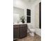 Modern bathroom with dark vanity, white toilet, and contemporary art at 5018 W Walatowa St, Laveen, AZ 85339