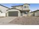 Two-story house with gray siding, a two-car garage, and a landscaped front yard at 5018 W Walatowa St, Laveen, AZ 85339