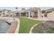 Spacious backyard oasis with a pergola, pond, and lush grass at 5287 W Quail Ave, Glendale, AZ 85308