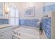 Bathroom with soaking tub and blue tile surround at 5287 W Quail Ave, Glendale, AZ 85308