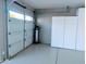 Clean garage with water softener, cabinets, and an automatic garage door at 5287 W Quail Ave, Glendale, AZ 85308