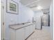 Bright laundry room with white cabinets and countertop, featuring a sink and refrigerator at 5287 W Quail Ave, Glendale, AZ 85308