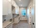 Bright laundry room with shaker cabinets, herringbone tile floor, and window at 601 E Amber Sun Dr, Phoenix, AZ 85085