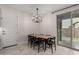 Bright dining area with chandelier, wooden table, and sliding glass door to backyard at 646 S Jacana Ln, Gilbert, AZ 85296