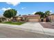 Single-story home with landscaped front yard, two-car garage, and inviting curb appeal at 7167 W Trails Dr, Glendale, AZ 85308