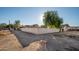 Side yard with a tall tree and gravel driveway at 7736 W Acoma Dr, Peoria, AZ 85381