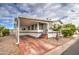 Mobile home with covered porch and red concrete driveway at 7750 E Broadway Rd # 674, Mesa, AZ 85208