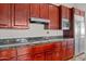 Well-equipped kitchen with dark wood cabinets and granite countertops at 8760 N 73Rd Way, Scottsdale, AZ 85258