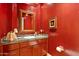 Powder room with dark red walls and granite countertop at 8760 N 73Rd Way, Scottsdale, AZ 85258