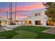 Landscaped backyard with putting green and modern home in background at 9809 E Desert Cove Ave, Scottsdale, AZ 85260