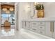 Spa-like bathroom with double vanity, marble accents, and a view of the backyard at 9809 E Desert Cove Ave, Scottsdale, AZ 85260