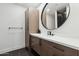 Contemporary bathroom with a floating vanity and a large round mirror at 9809 E Desert Cove Ave, Scottsdale, AZ 85260