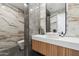 Elegant powder room with marble tile and a sleek floating vanity at 9809 E Desert Cove Ave, Scottsdale, AZ 85260