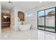 Luxurious bathroom featuring a freestanding tub, marble flooring, and a glass-enclosed shower at 9809 E Desert Cove Ave, Scottsdale, AZ 85260