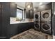 Modern laundry room with dark cabinetry and high-end appliances at 9809 E Desert Cove Ave, Scottsdale, AZ 85260