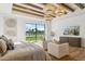 Luxurious main bedroom with wood beams, large windows and sitting area at 9809 E Desert Cove Ave, Scottsdale, AZ 85260