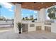 Modern outdoor kitchen with stainless steel appliances and wood ceiling at 9809 E Desert Cove Ave, Scottsdale, AZ 85260