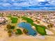 Aerial view of a golf course community with houses, a lake, and mountains in the background at 14328 W Dusty Trail Blvd, Sun City West, AZ 85375