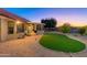 Landscaped backyard with covered patio and putting green at 14328 W Dusty Trail Blvd, Sun City West, AZ 85375