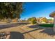 Landscaped backyard with rock and gravel, a green lawn, and trees at 14328 W Dusty Trail Blvd, Sun City West, AZ 85375