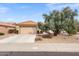 Single-story home with attached garage, desert landscaping, and a large tree in front at 14414 W Wagon Wheel Dr, Sun City West, AZ 85375