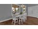 Bright dining area with white table and chairs, hardwood floors, and view to backyard at 1570 W Bartlett Way, Chandler, AZ 85248