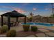 Inviting backyard oasis with sparkling pool, covered patio, and lush landscaping at 1570 W Bartlett Way, Chandler, AZ 85248