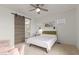 Bedroom with a queen bed, sliding barn door, and ceiling fan at 1685 S Wallrade Ln, Gilbert, AZ 85295