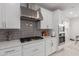 Modern kitchen features gas cooktop, stainless steel appliances, and gray tile backsplash at 1685 S Wallrade Ln, Gilbert, AZ 85295