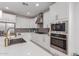 Modern kitchen with white cabinets, stainless steel appliances, and quartz countertops at 1685 S Wallrade Ln, Gilbert, AZ 85295