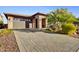 House exterior with a brick driveway and desert landscaping at 17676 E Woolsey Way, Rio Verde, AZ 85263