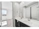 Bathroom featuring double sinks, dark cabinetry, and neutral paint, with a peek into bedroom at 18950 W Stella Ave, Waddell, AZ 85355