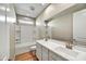 Bright bathroom featuring a double vanity, white tiled tub, and wood-look floors at 19026 W Stella Ave, Waddell, AZ 85355